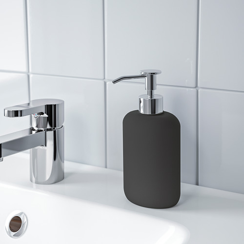 Dispensador de jabón negro con bomba metálica sobre lavabo blanco, parte de la serie EKOLN para un aspecto de baño moderno.