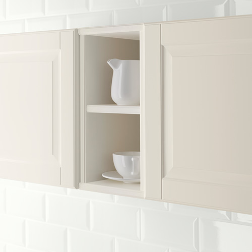 Un gabinete de cocina de color crema con estanterías abiertas que sostienen vajilla blanca, lo que demuestra el almacenamiento y la exhibición accesibles.