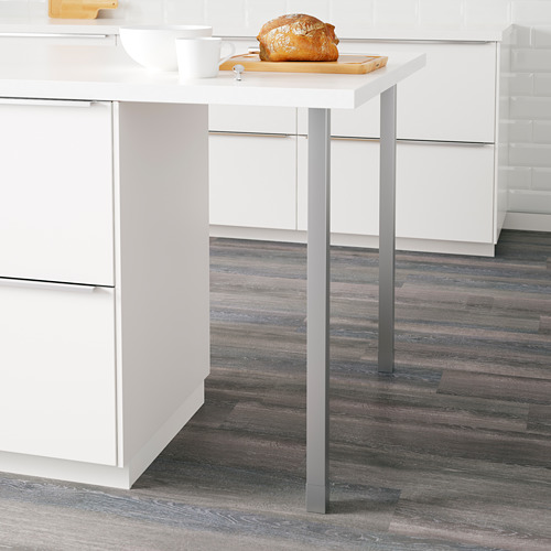 Pequeño soporte de cocina con patas metálicas ajustables que soporta una mesa de madera con una barra de pan encima.