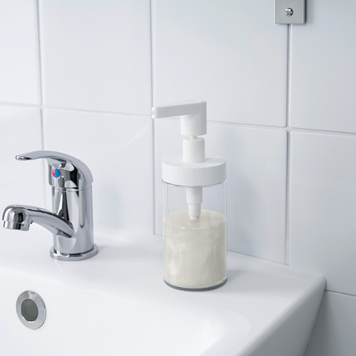 Lavabo de baño moderno con grifo cromado y dispensador de jabón transparente relleno de jabón líquido.