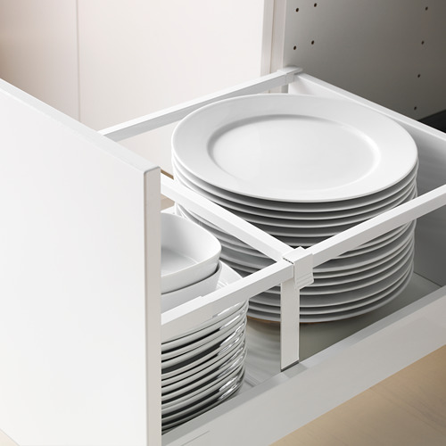 Armario de cocina abierto que muestra platos y tazones blancos apilados en un cajón organizado con un aspecto moderno.