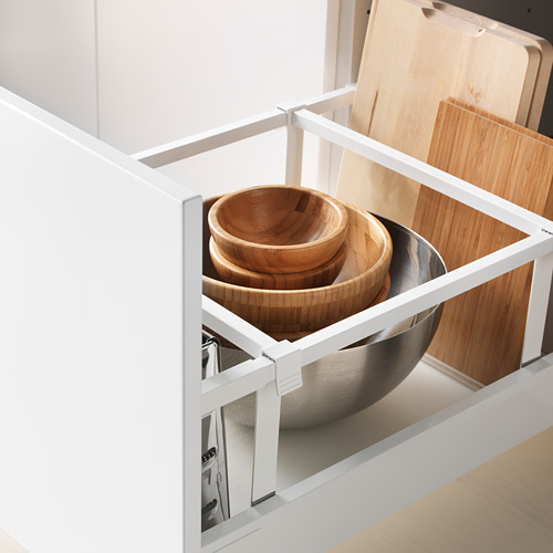 Cajón de cocina abierto con cuencos de madera apilados y cuenco de metal, que muestra almacenamiento y organización.