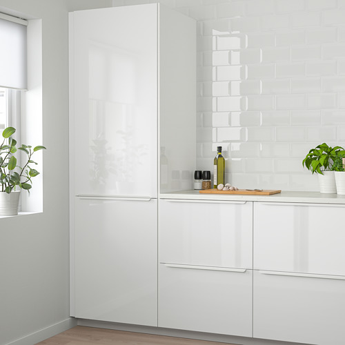 Cocina blanca moderna con gabinetes brillantes. Cajones brillantes y columnas más altas que la ventana. Plantas verdes en la encimera.