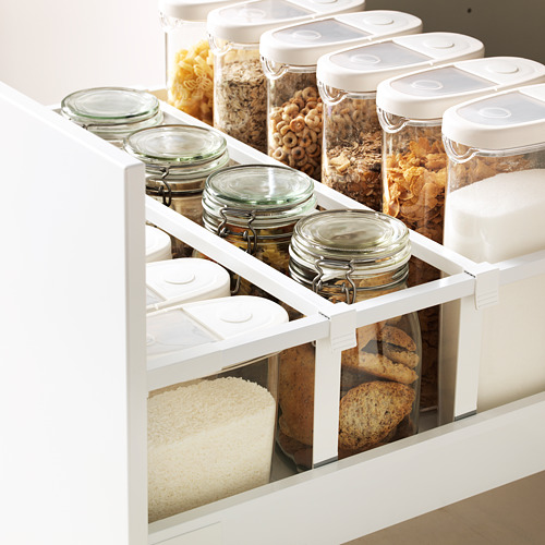 Un cajón de cocina con recipientes de vidrio ordenados que almacenan granos, cereales y pan, que muestran un almacenamiento eficiente de METOD.