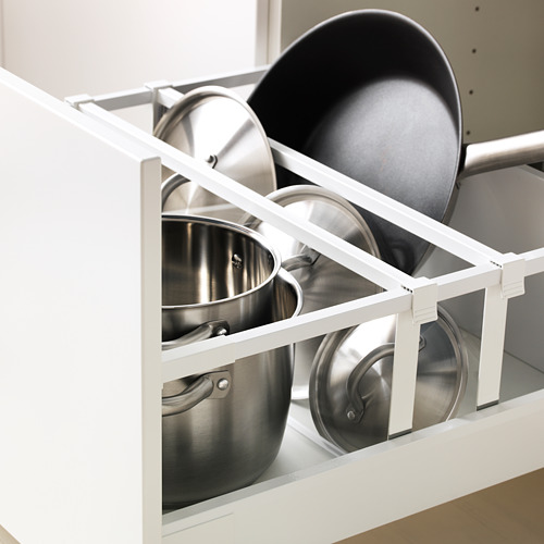 Organizador de cajones de cocina con ollas y sartenes en armario blanco.