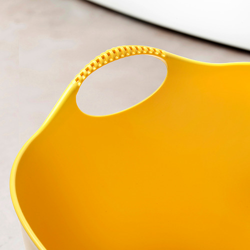 Cesta de lavandería flexible de color amarillo brillante con asas resistentes, colocada sobre una superficie de color claro.