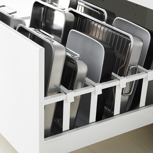 Organizador de cajones de cocina con divisores blancos que sujetan bandejas metálicas para hornear, lo que garantiza un almacenamiento ordenado y un fácil acceso.