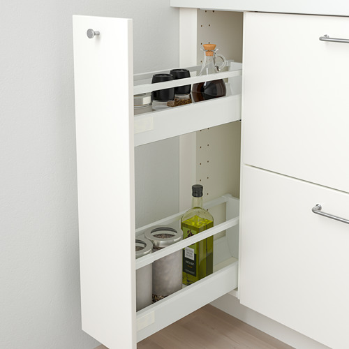 Mueble de cocina blanco con cajón extraíble, con tarros de especias y botella de aceite de oliva.