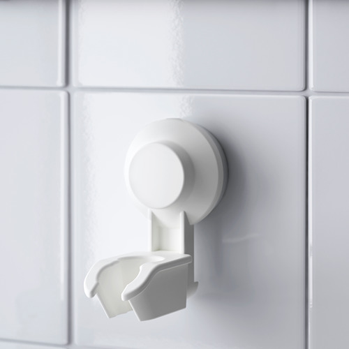 Soporte de ducha con ventosa blanco montado sobre baldosas brillantes, sujetando de forma segura el soporte vacío en perfecto estado.
