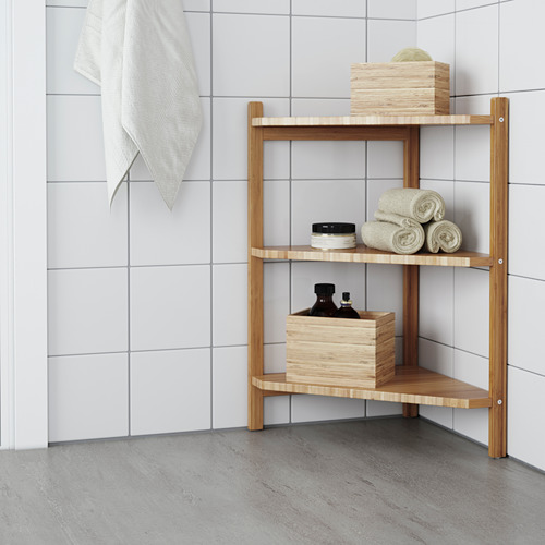 Estante de bambú de esquina con toallas y cajas en el baño con azulejos blancos.