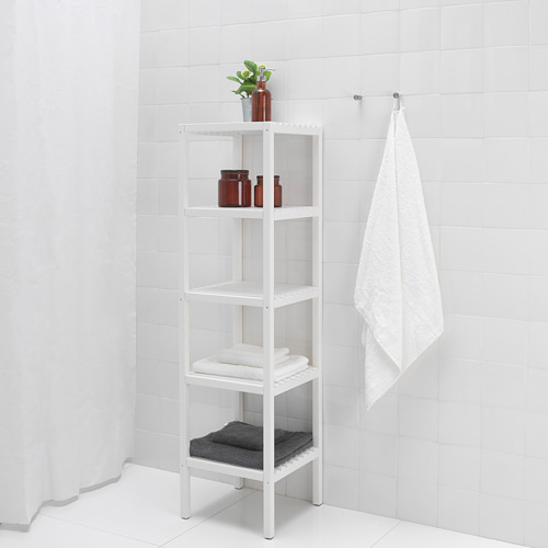Una estantería de baño blanca alta contiene toallas, botellas y una planta, optimizando el espacio con múltiples estantes abiertos.