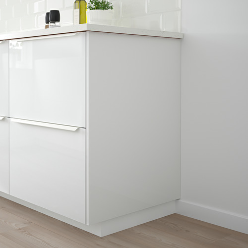 Gabinete de cocina blanco con acabado brillante, manijas elegantes, planta, botella y parlante en el mostrador.