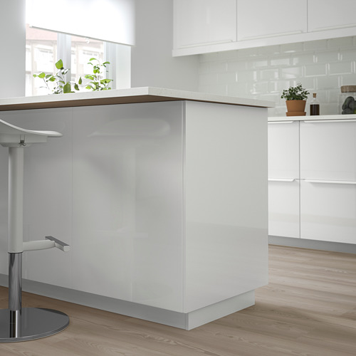 Moderna isla de cocina blanca con acabado brillante, superficies elegantes y líneas limpias, colocada en el centro con contraste de suelo de madera.