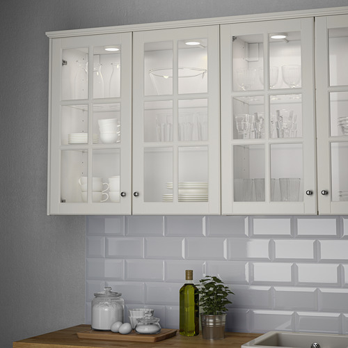 Cocina moderna con vitrinas, aceite de oliva y plantas.