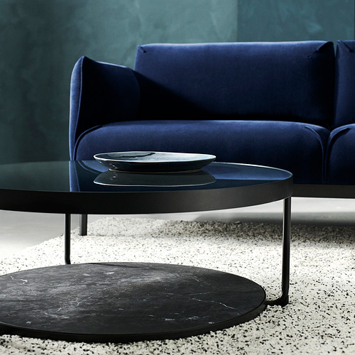 Salón moderno: sofá azul, mesita redonda negra con tapa de cristal.