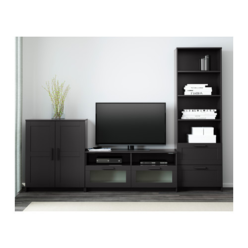 Mueble de tv moderno con pantalla plana, cajones, estantes, armarios negros, estantería con decoración y libros.