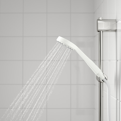 Ducha de mano en uso, amplio chorro frente a pared alicatada, soporte cromado adjunto.