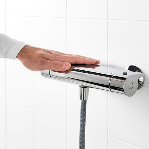 En una mano ajusta un mezclador de ducha termostático. El mezclador tiene un tope de seguridad de 38 ° C, lo que garantiza que el agua no se caliente demasiado.