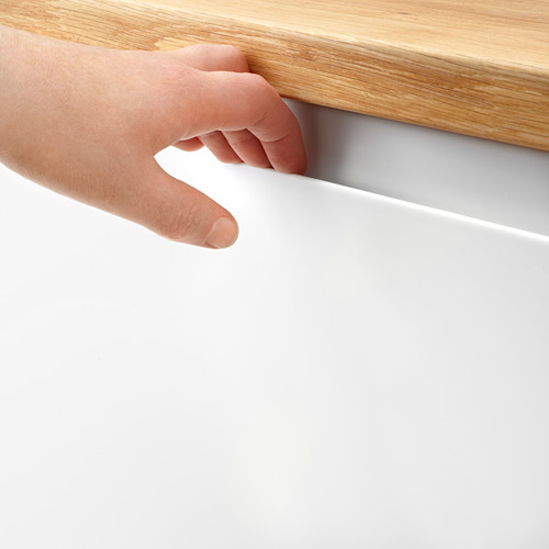La mano toca el borde de la estantería de madera.
