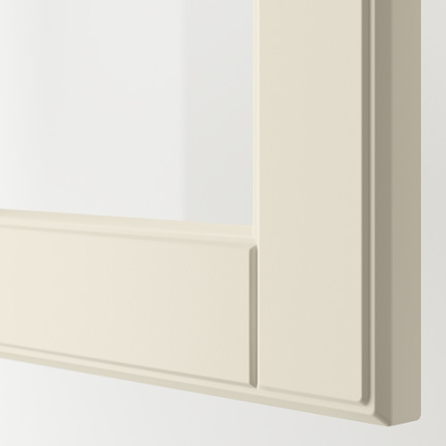 Primer plano de una puerta de armario de cocina BODBYN lisa y blanquecina con bordes biselados y un tirador delgado y rectangular.