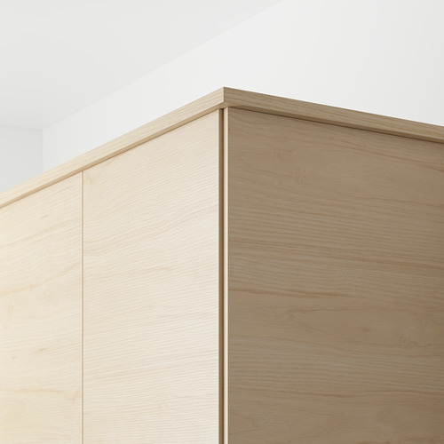 Primer plano de los paneles de fresno claro ASKERSUND, que muestran una superficie de melamina fácil de limpiar y un patrón de madera, ideal para ocultar los accesorios de iluminación y los cables de la cocina.