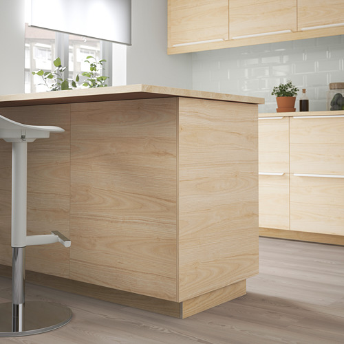 Cocina moderna con isla de madera clara, taburetes y armarios. Diseño ASKERSUND. Limpio, organizado y espacioso.