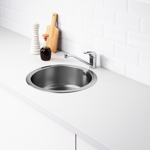 Fregadero de acero inoxidable con grifo cromado, diseño de cocina moderno con encimera blanca y protector contra salpicaduras. Incluye trampa de agua y colador.