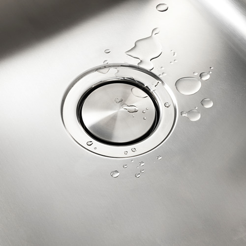 Tapa del fregadero de acero inoxidable con base magnética, gotas de agua dispersas, superficie plana limpia.