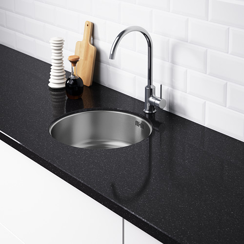 Fregadero de cocina moderno con grifería cromada y encimera negra. Fregadero de acero inoxidable, sin agujeros pretaladrados. Salpicadero de azulejos blancos.