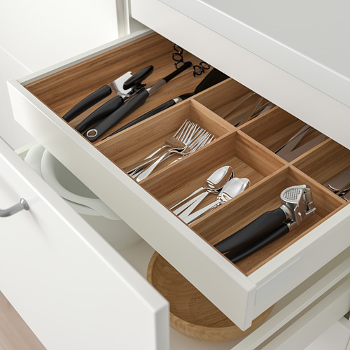 Cajón de cubiertos organizado con compartimentos en cocina moderna.