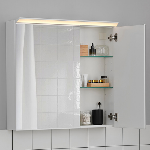 Moderno mueble de baño con espejo con luz led y estantes de vidrio, exhibiendo artículos de tocador y cosméticos.