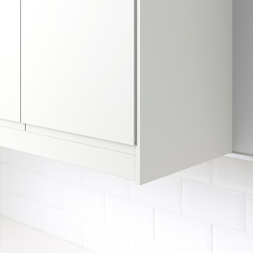 Moldura de esquina blanca en pared de azulejos, ocultando unidades de iluminación y cables debajo de los gabinetes.