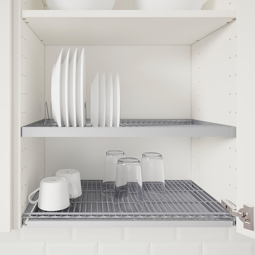 Mueble de cocina con dos estantes. El estante superior contiene platos blancos. El estante inferior contiene vasos transparentes y tazas blancas. Estantes metálicos ajustables.