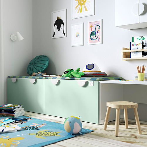 Habitación infantil con banco verde SMÅSTAD para guardar juguetes, alfombra de colores, taburete de madera y arte de pared. Diseño brillante y divertido, perfecto para jugar.