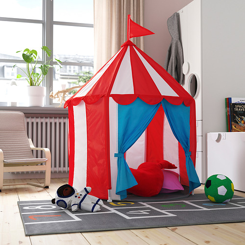 Carpa de juegos para niños roja y azul, CIRKUSTÄLT, en la sala de estar. Colores brillantes, materiales suaves. Más grande que un juguete, más pequeño que una silla.
