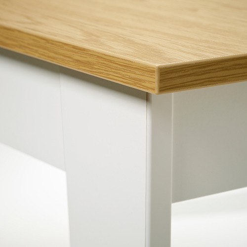 Mesa moderna de madera con acabado claro, bordes elegantes y robustas patas de metal blanco.