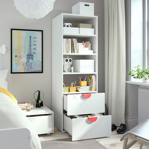 Un dormitorio infantil con estantería SMÅSTAD que muestra cajones de almacenamiento y estantes llenos de libros y juguetes.