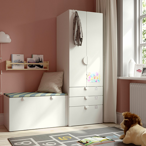 Habitación infantil con armario SMÅSTAD, banco, estantería para libros y alfombra de colores.