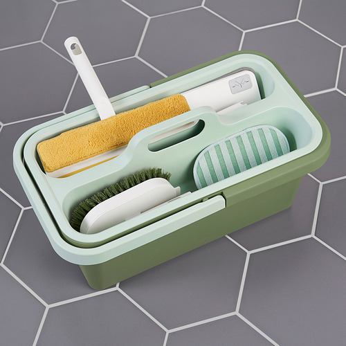 Cubo de limpieza de plástico verde con mango, herramientas de sujeción: esponja, cepillos y paño. Suelo hexagonal de baldosas grises.