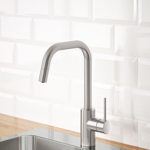 Grifo de cocina de acero inoxidable con caño extraíble para un enjuague eficiente, montado sobre encimera de madera contra pared de azulejos blancos.