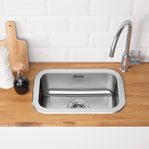 Fregadero de cocina de acero inoxidable con encimera de madera, grifo plateado, desagüe y protector contra salpicaduras blanco.
