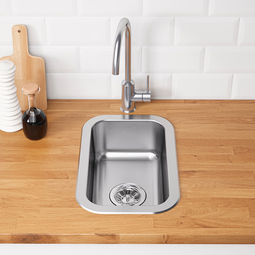 Fregadero de cocina de acero inoxidable en encimera de madera con grifo moderno y área de preparación de alimentos.