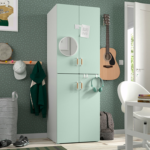 Armario SMÅSTAD verde con espejo, puertas de cierre suave, guitarra, silla.
