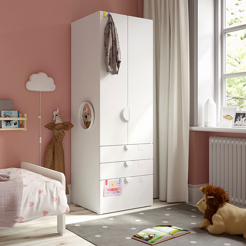 Habitación para niños con armario SMÅSTAD, cama, alfombra y peluches. El armario es alto con espejo y cajones.