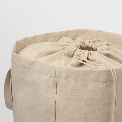 Bolso tote cilíndrico de tela beige con cierre de cordón. Asas a ambos lados para transportar. Diseño sin costuras, listo para las tareas de lavandería.