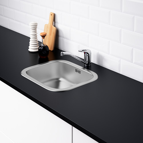 Fregadero de cocina moderno en acero inoxidable con material fonoabsorbente, montado en encimera negra. Grifo cromado incluido.