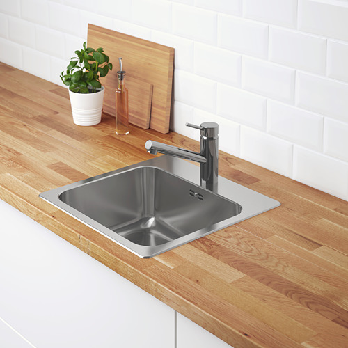Fregadero de acero inoxidable con grifería cromada en encimera de madera.