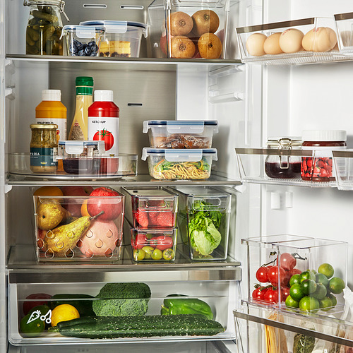 Nevera bien organizada con frutas y verduras en cestas transparentes KLIPPKAKTUS, que mantienen los artículos visibles y frescos.