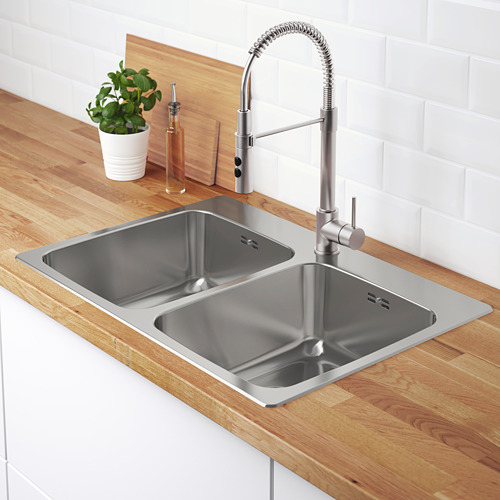 Fregadero doble de acero inoxidable con grifo elegante y encimera moderna.