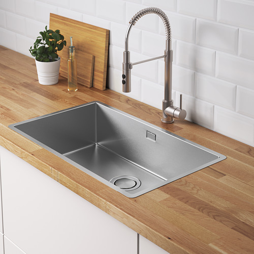 Fregadero de cocina moderno con grifo de acero cepillado, encimera de madera y planta. Una tapa de colador de acero inoxidable.